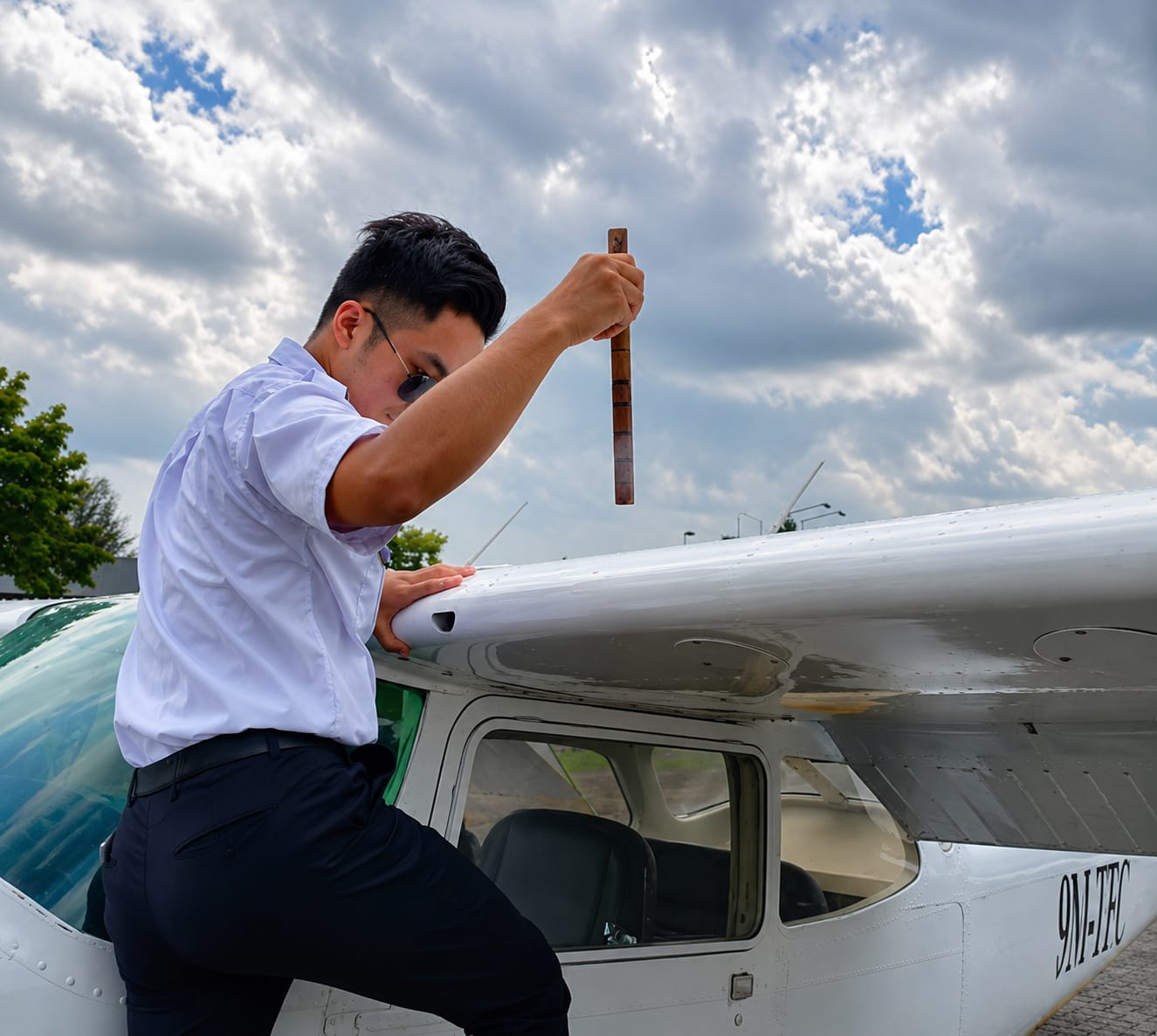 Student pilot performing pre-flight fuel check